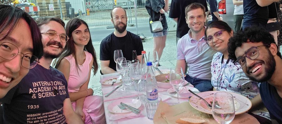 The group around a table at an outdoor restaurant in Berlin on a summer evening.